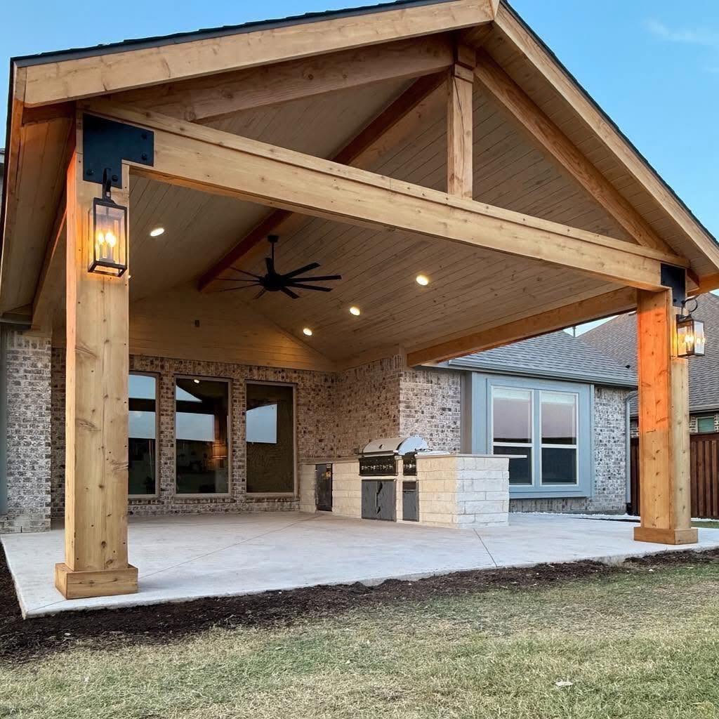 Dark stained pergola over an outdoor lounge with mounted TV, linear fireplace and slat privacy walls